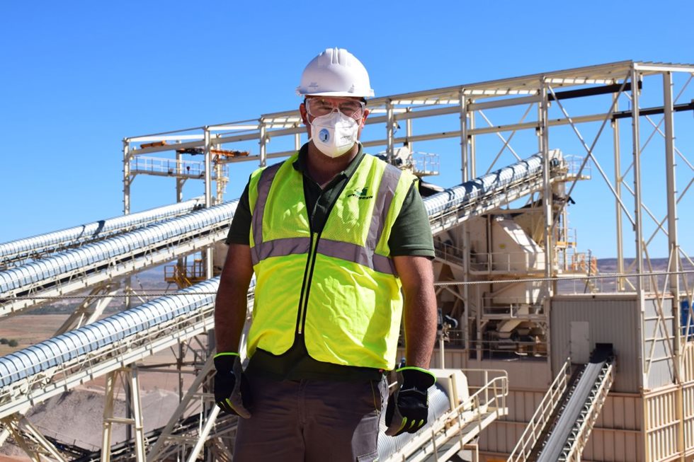 A person standing in front of conveyors at Emipesa site.