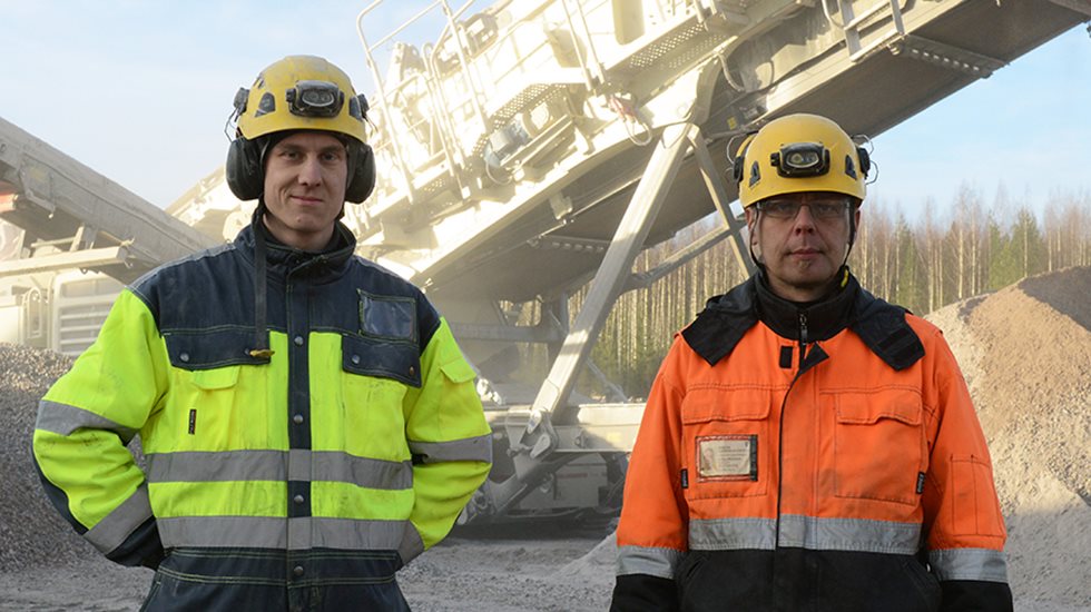 Two men posing for the camera in safety gear with Lokotrack LT330D in the background.