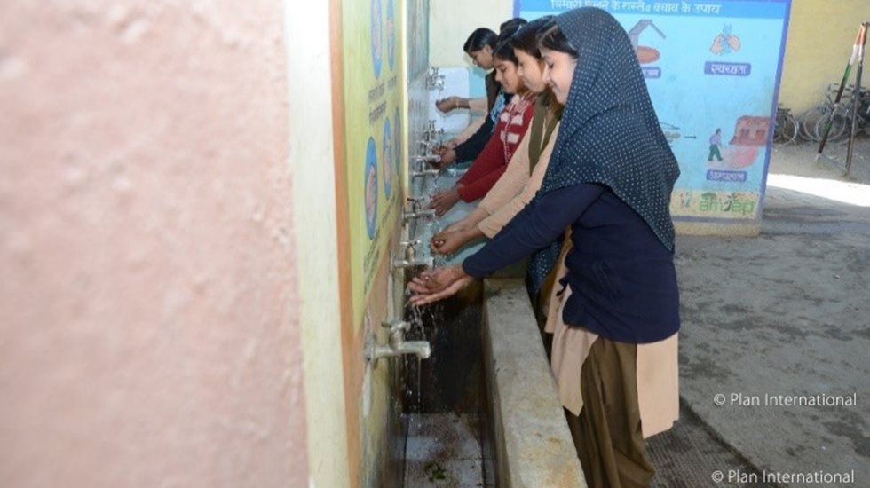 Girls washing hands in school in India. 