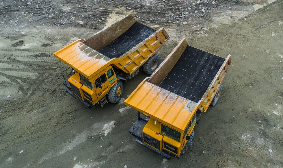Dois caminhões equipados com revestimentos Trellex parados em uma pedreira
