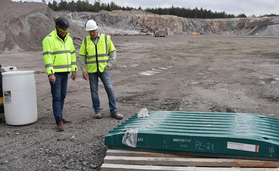 Two men looking at Metso jaw crusher wear parts at a quarry.