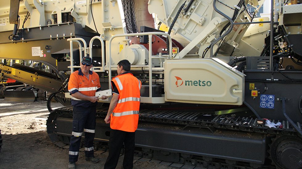 Two employees in front of Metso Outotec's Lokotrack