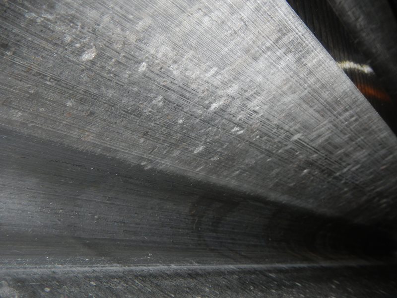 Indentations caused from iron ore foreign particles trapped in the gear mesh in operation